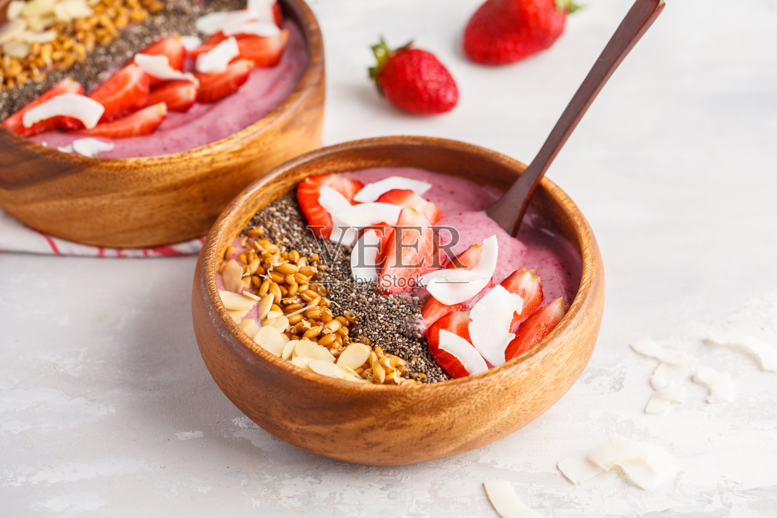 素食早餐概念。草莓奶昔碗，杏仁，奇亚，芽和椰子。照片摄影图片
