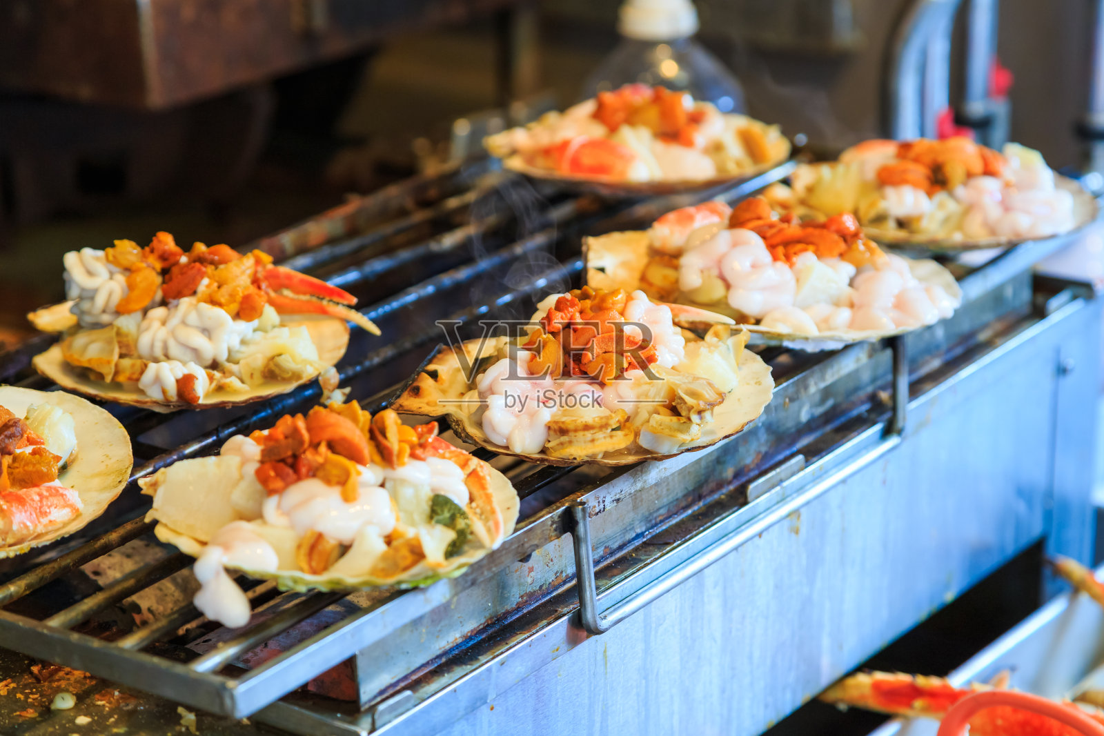 烤海贝海鲜，日本筑地鱼市的日本街头小吃。有选择性的重点照片摄影图片