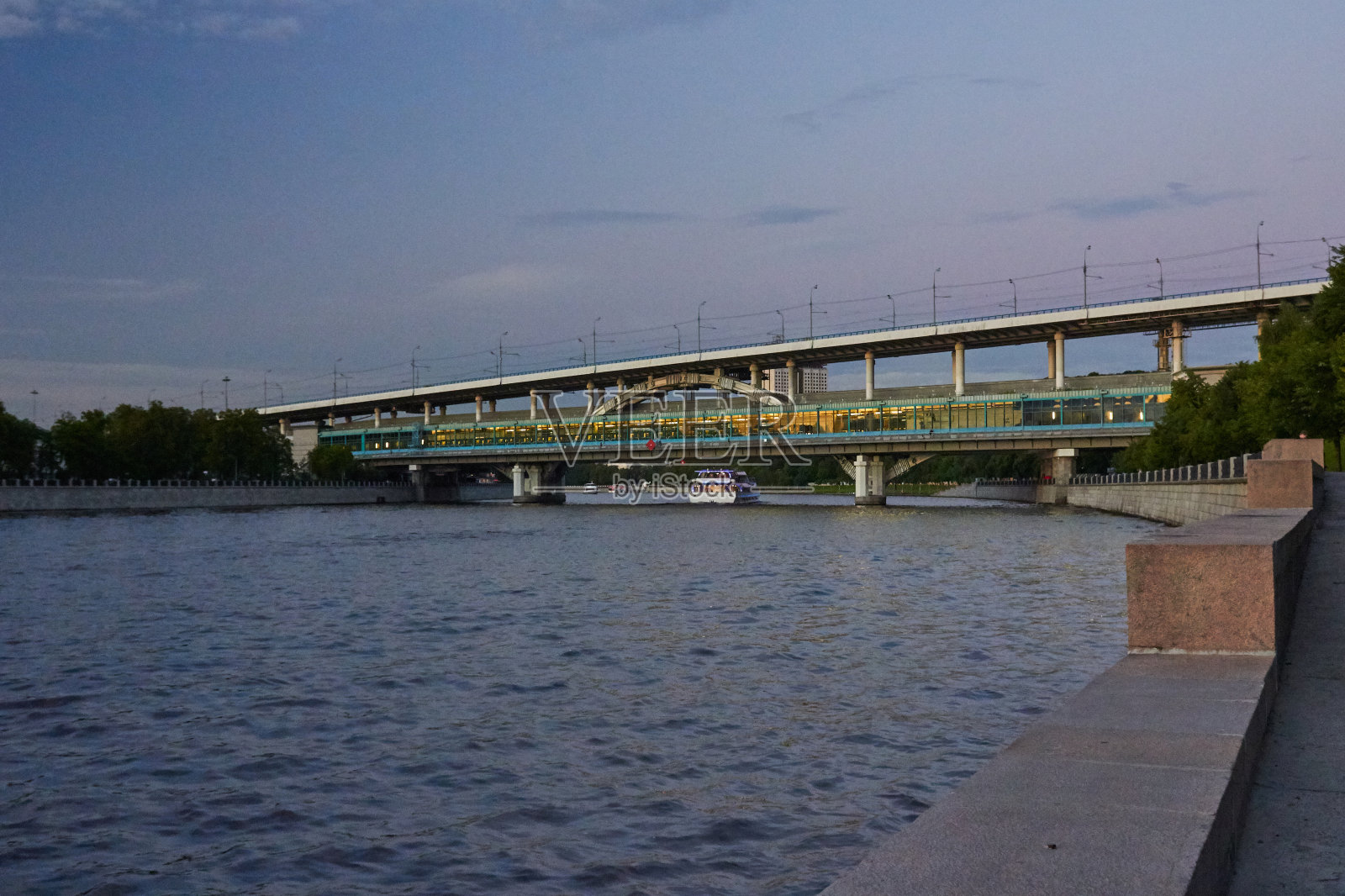 黄昏时分，河上的地铁桥照片摄影图片