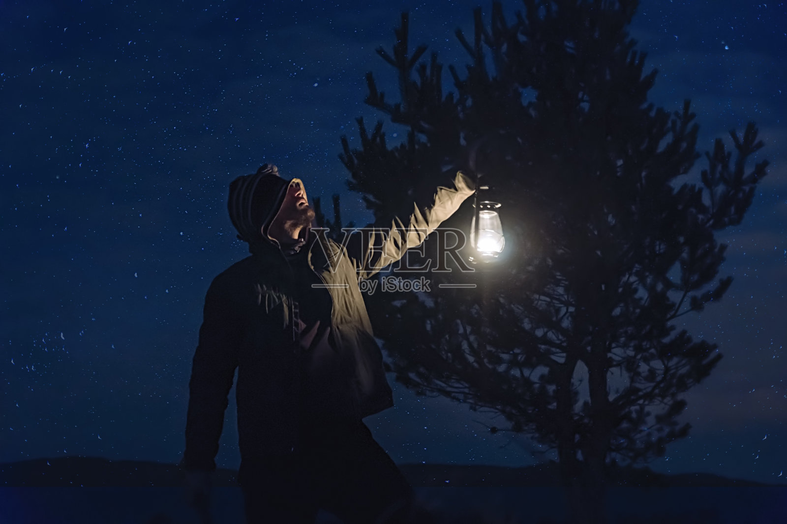 夜晚在森林里，手持煤气灯的人照片摄影图片