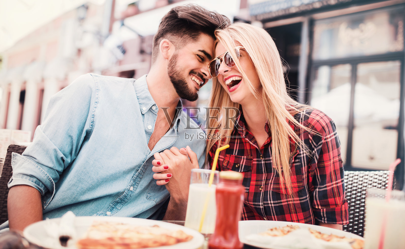 恩爱夫妻坐在咖啡馆吃披萨。消费主义、食品、生活理念照片摄影图片