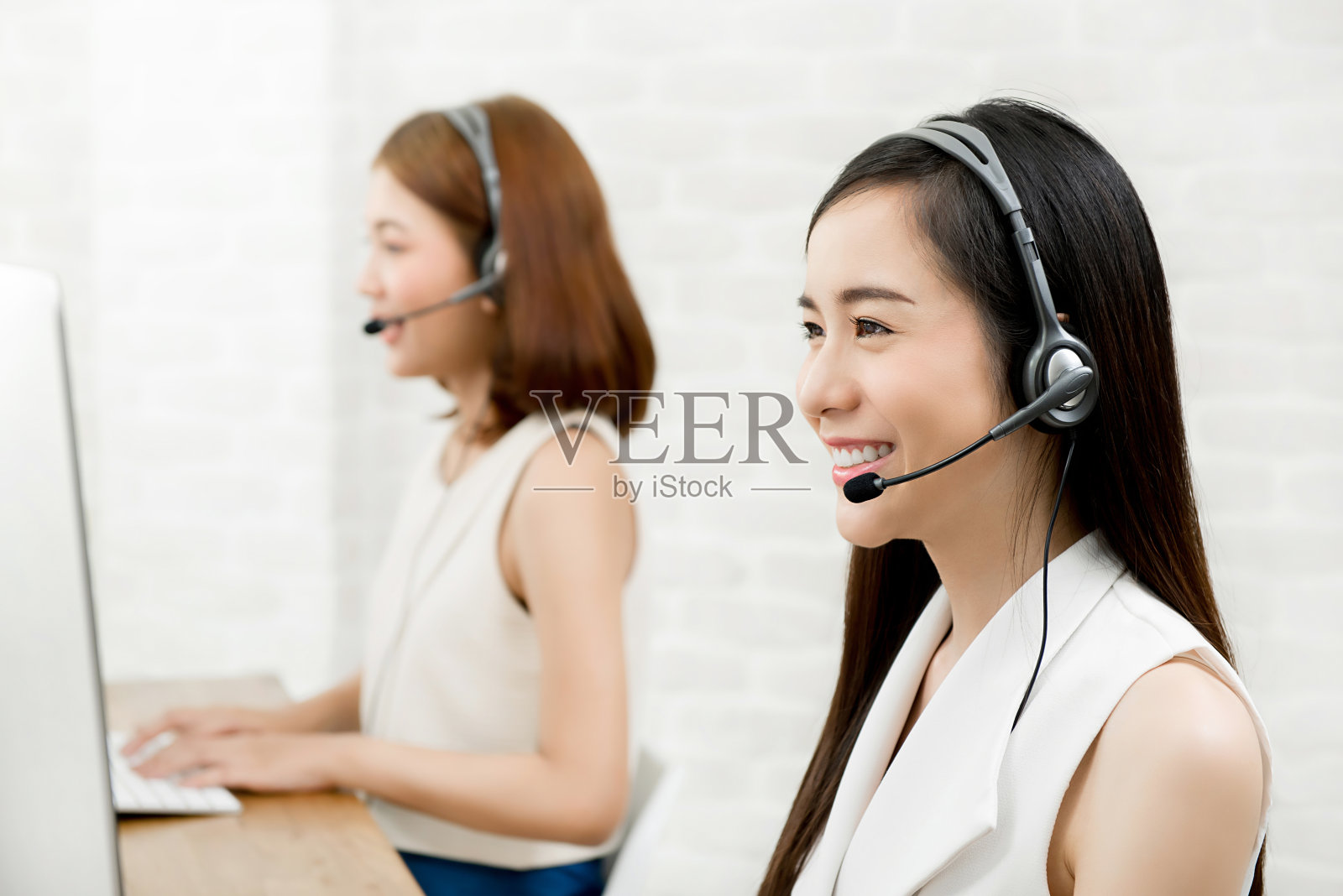 在呼叫中心工作的亚洲女性电话营销客户服务人员团队照片摄影图片
