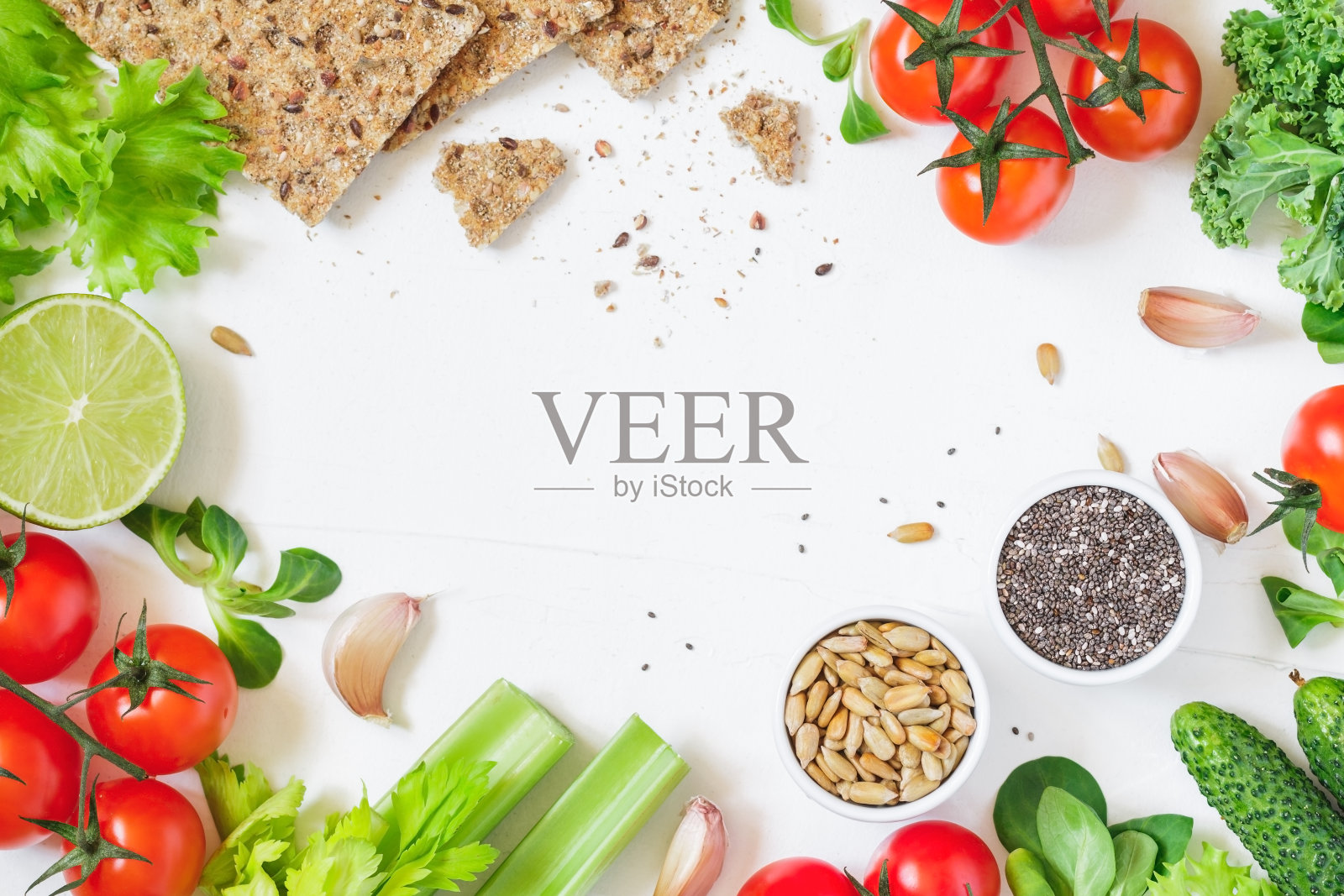 顶视图的新鲜蔬菜和全谷物面包在白色的背景。健康有机食品框架。平的。照片摄影图片