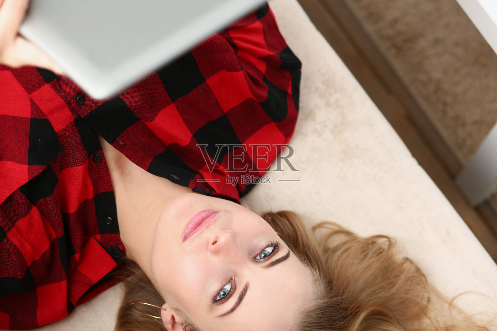 年轻漂亮的女人躺在沙发上用笔记本电脑工作照片摄影图片