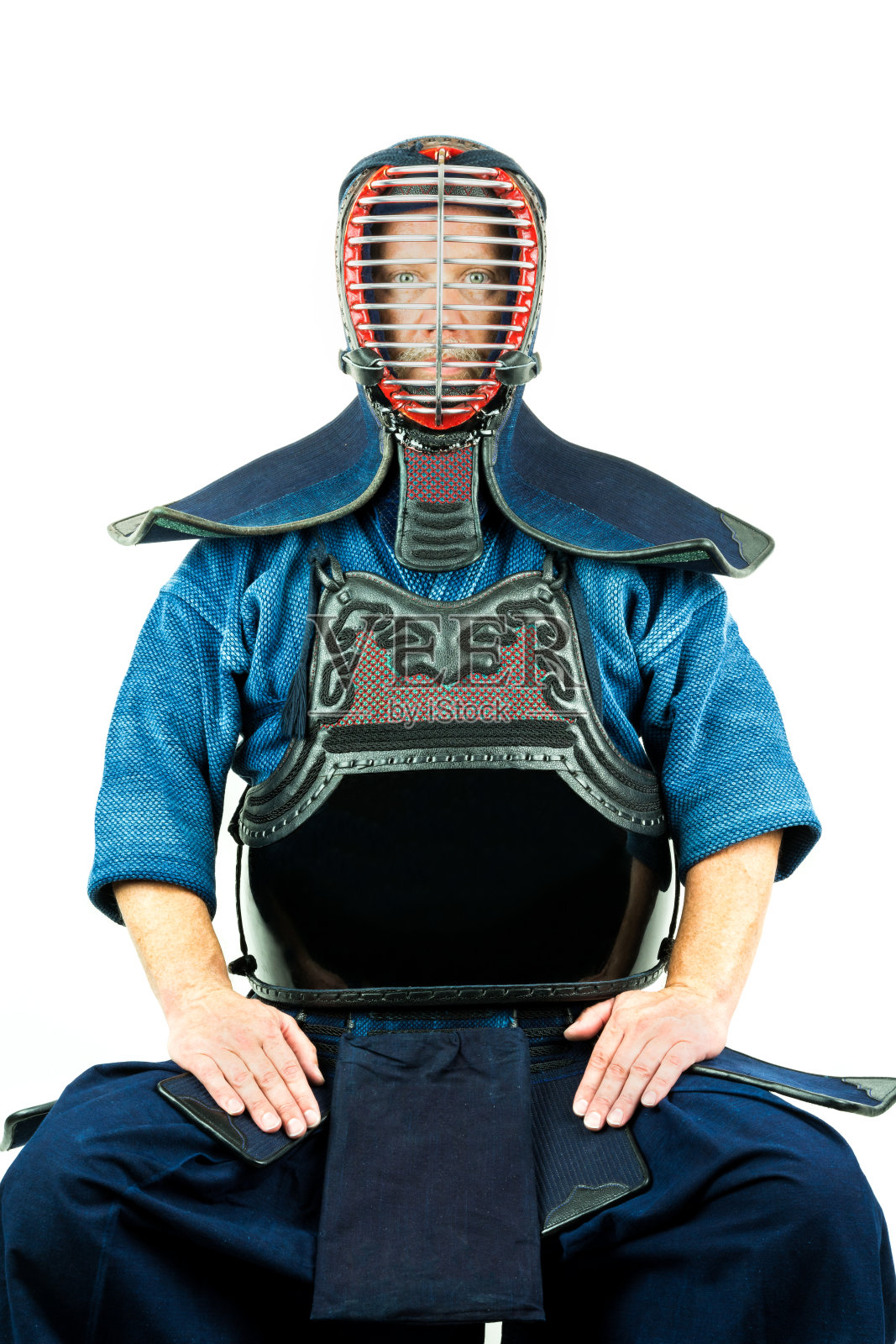 男性穿着剑道盔甲戴头盔，坐姿。照片摄影图片