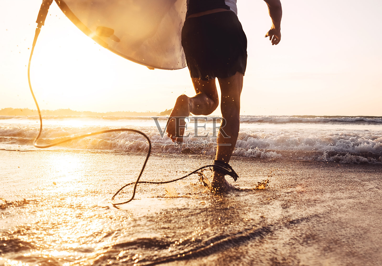 男子冲浪者与冲浪板在海洋中奔跑。积极的度假，健康的生活方式和运动概念形象照片摄影图片
