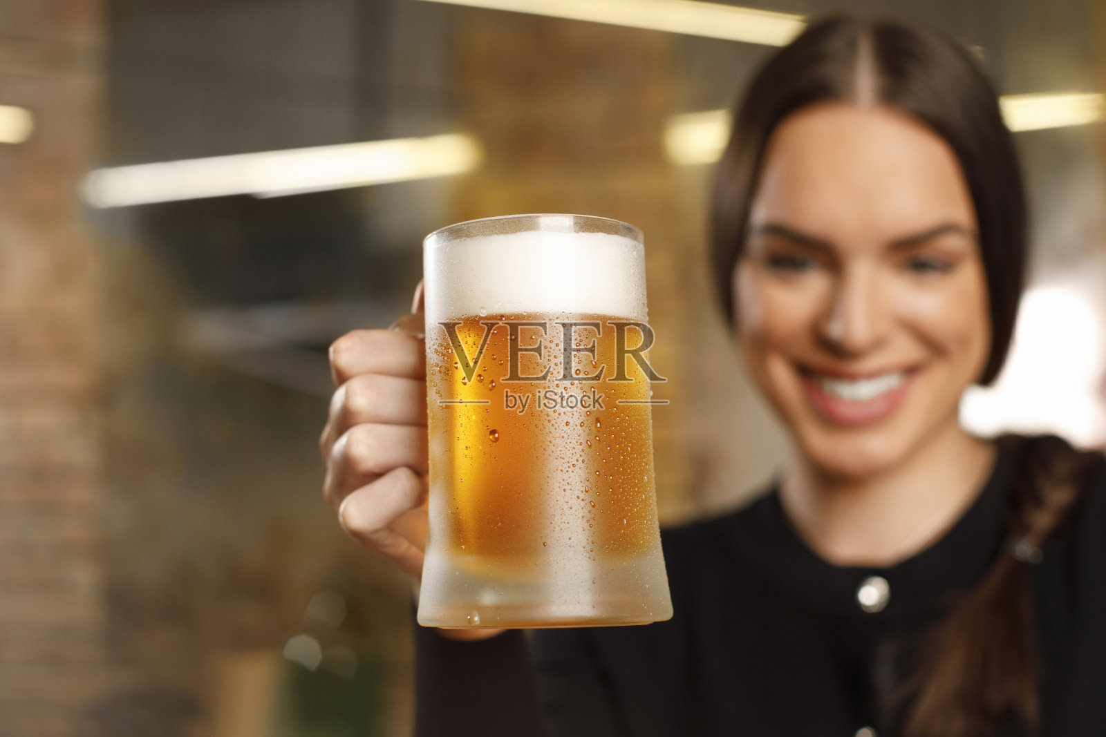 女人喝啤酒冰镇啤酒覆盖着凝结的水珠老复古酒吧的背景照片摄影图片