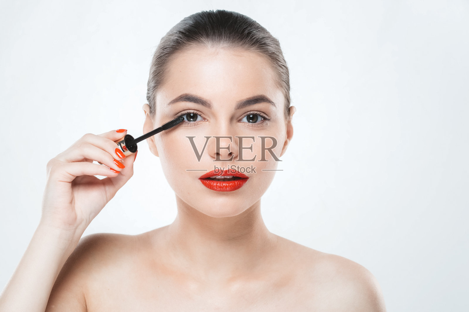 用睫毛膏化妆的女人脸上有红色的嘴唇和指甲孤立的白色照片摄影图片
