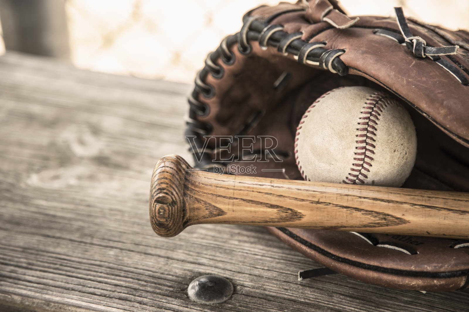 棒球赛季到了。教练席上的球棒、手套和球。照片摄影图片