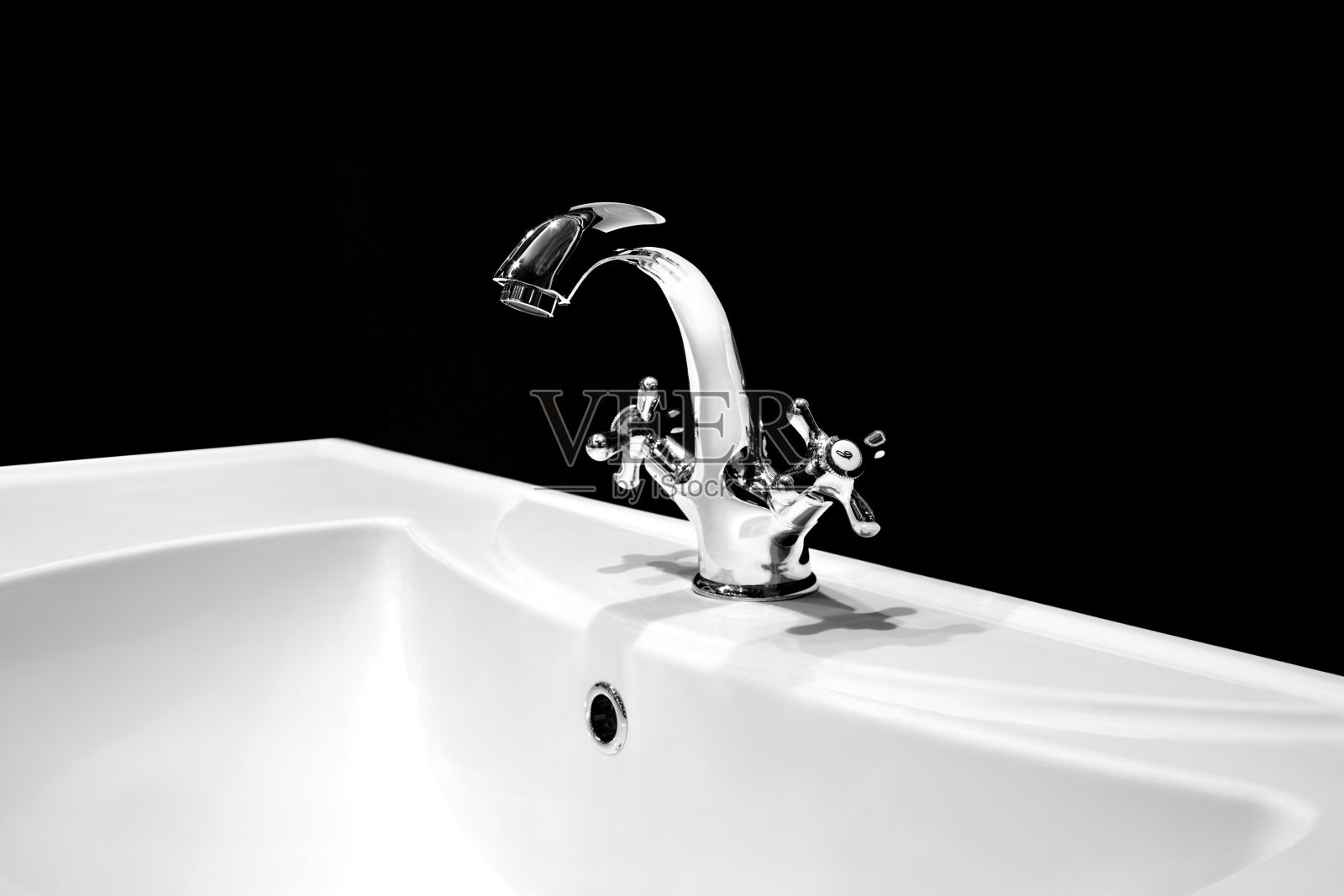 豪华水龙头搅拌器在一个美丽的黑色浴室的白色水槽照片摄影图片