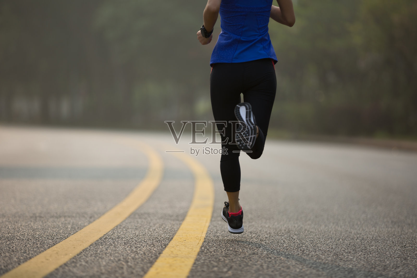 在小道上跑步的健身女运动员照片摄影图片