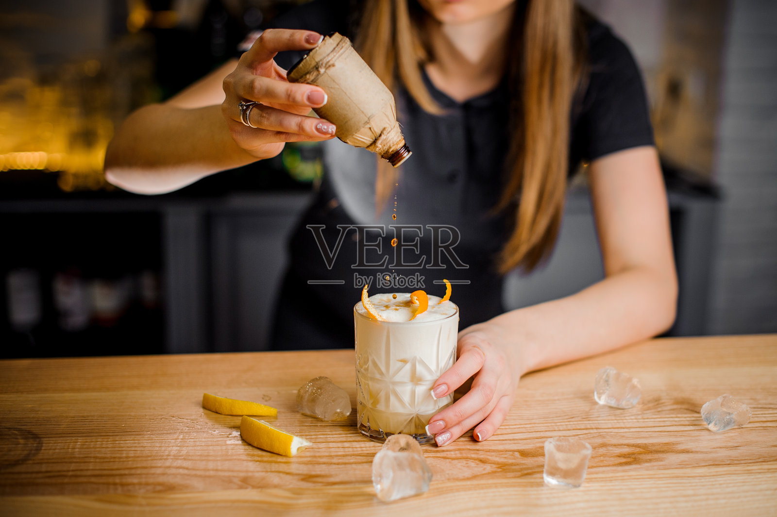 咖啡师在鸡尾酒中加入橘子皮照片摄影图片