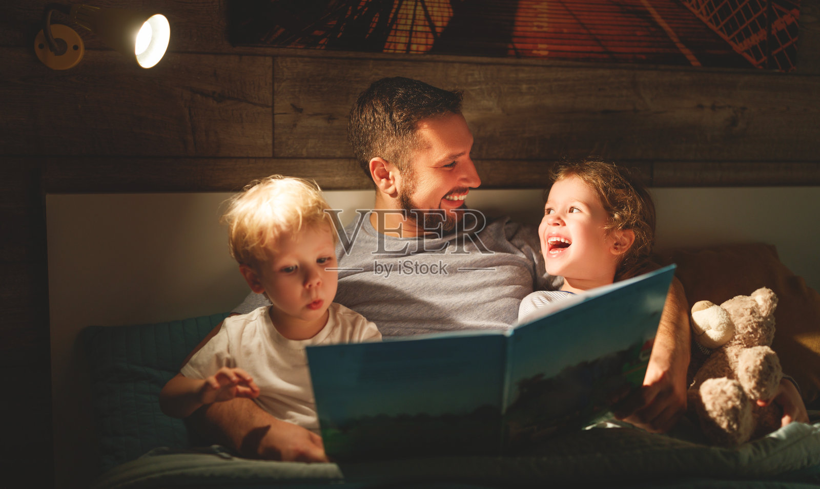 晚上家人阅读。父亲给孩子读书。睡觉前要看书照片摄影图片