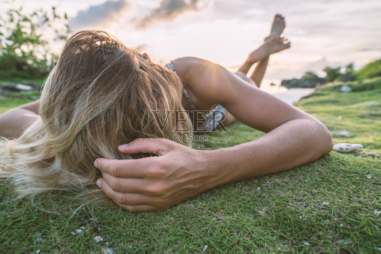年轻女子在热带岛屿放松日落，性感照片摄影图片