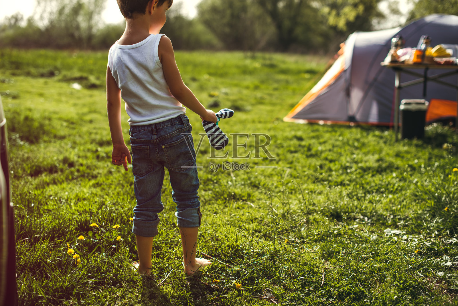 一个光着脚的男孩在露营照片摄影图片