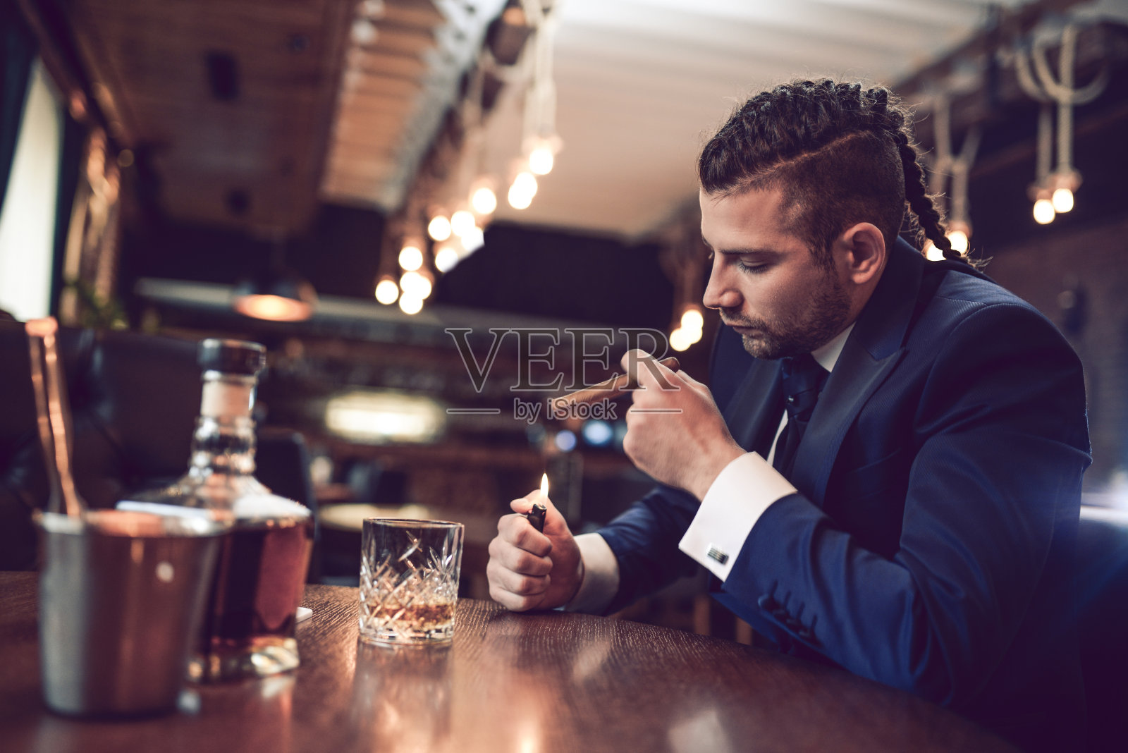 在餐馆里点着雪茄喝威士忌的商人照片摄影图片