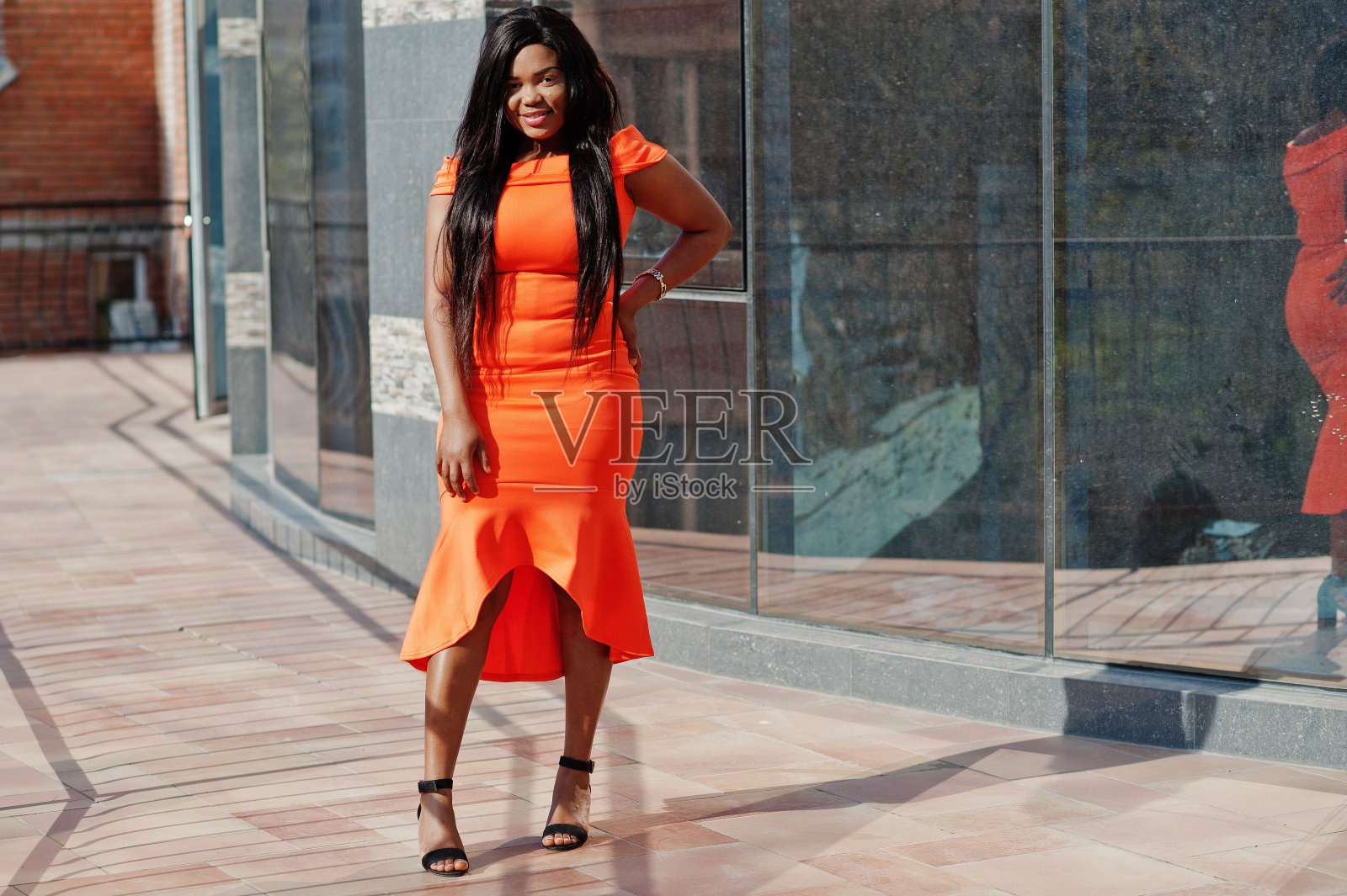 非裔美国女模特xxl穿橙色的衣服。照片摄影图片