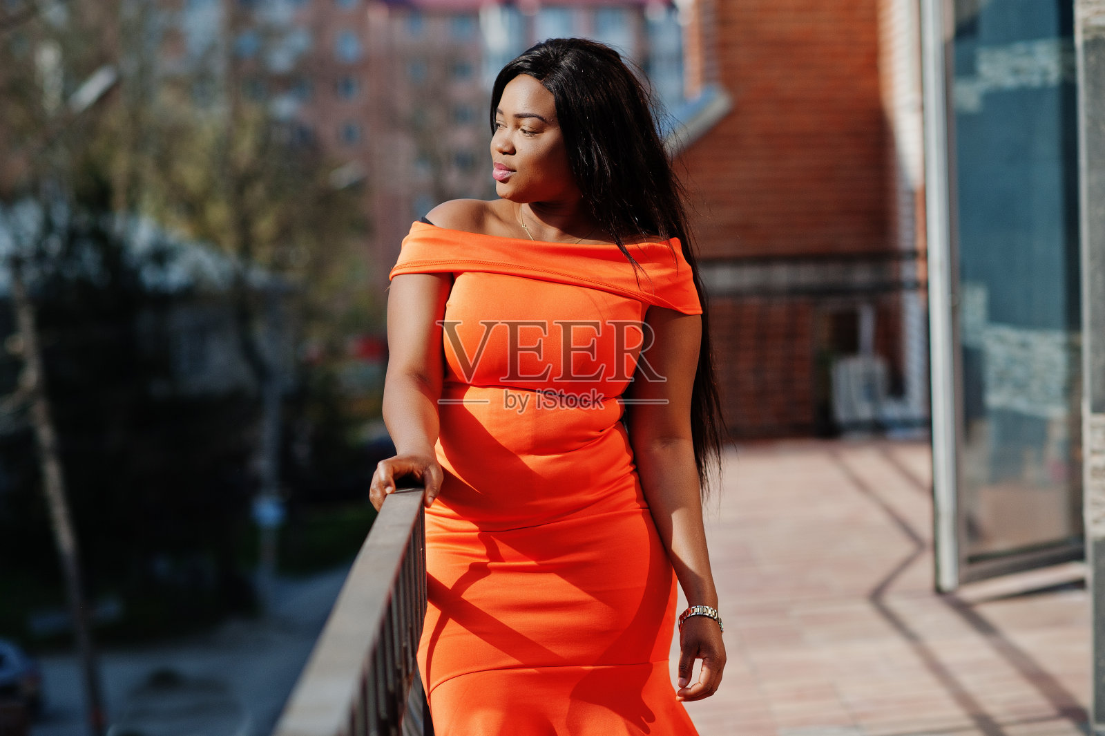 非裔美国女模特xxl穿橙色的衣服。照片摄影图片