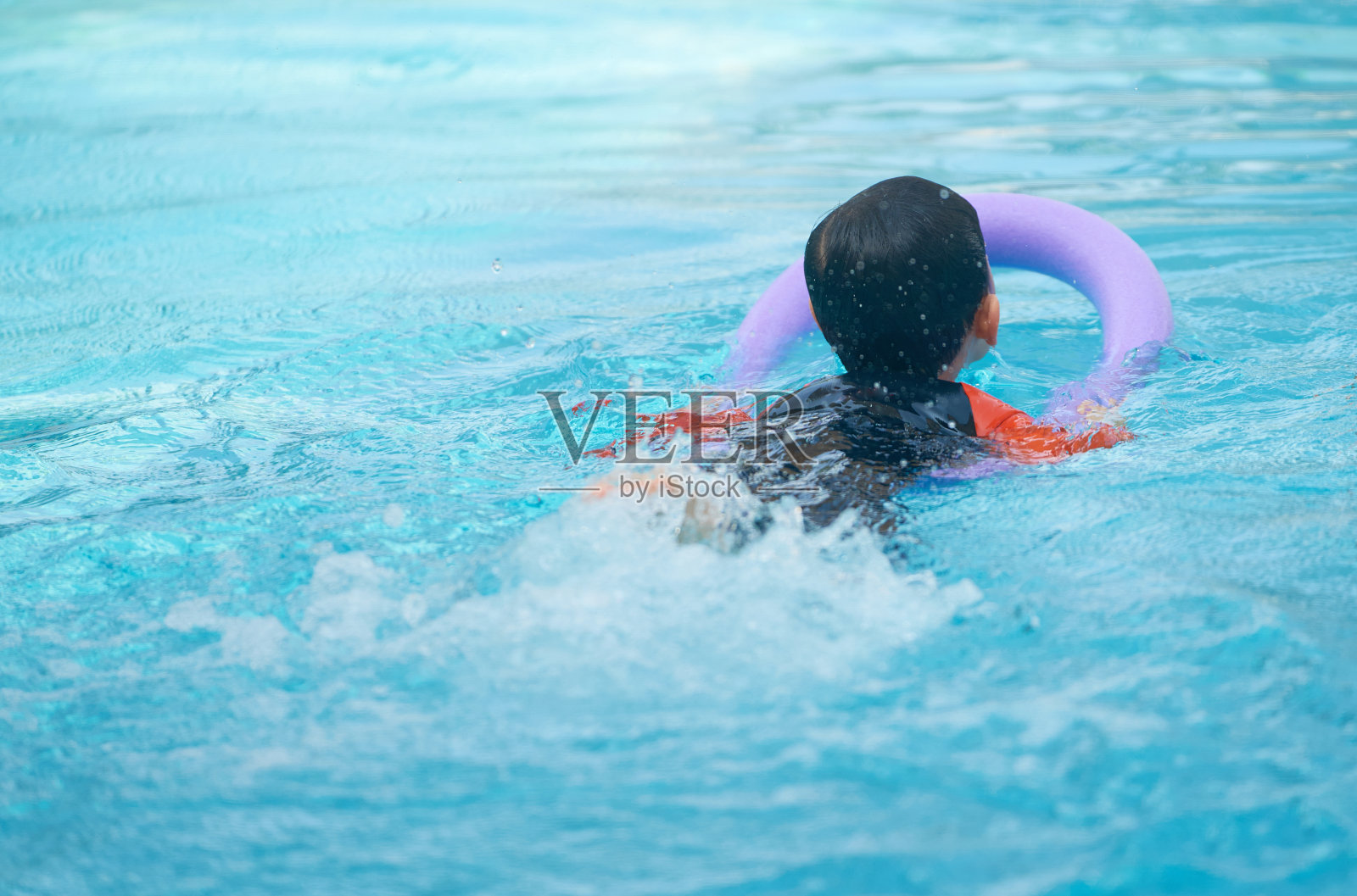 小朋友在泳池里用泡沫面学游泳，后视镜照片摄影图片