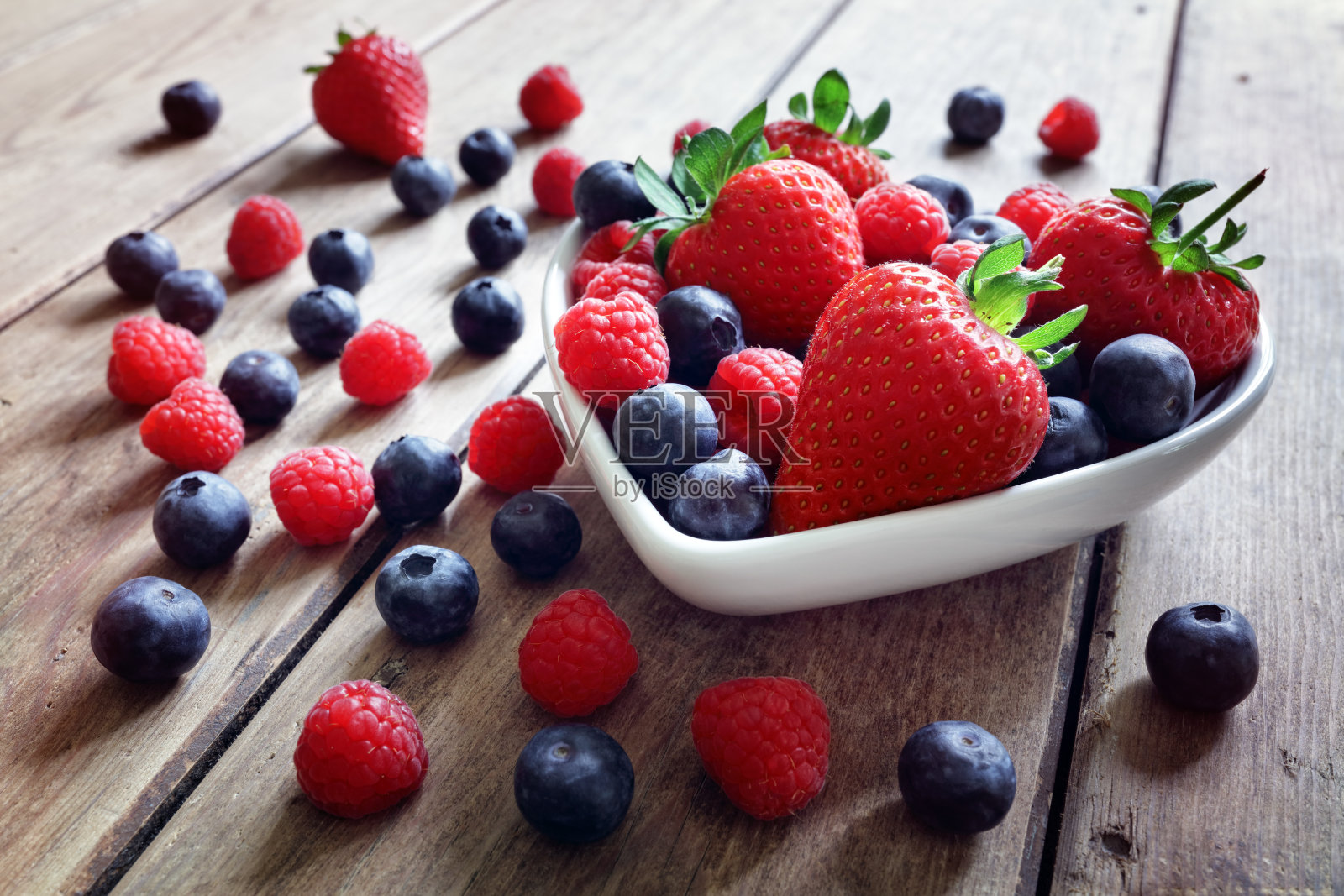 草莓，蓝莓和覆盆子水果在一个碗里照片摄影图片