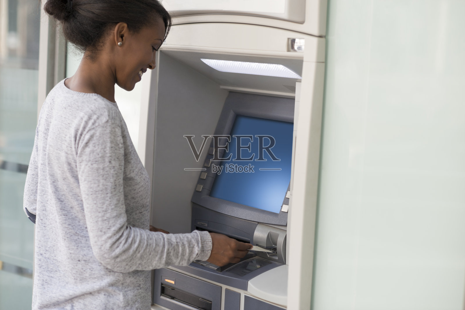 一名银行顾客从自动取款机取钱。照片摄影图片