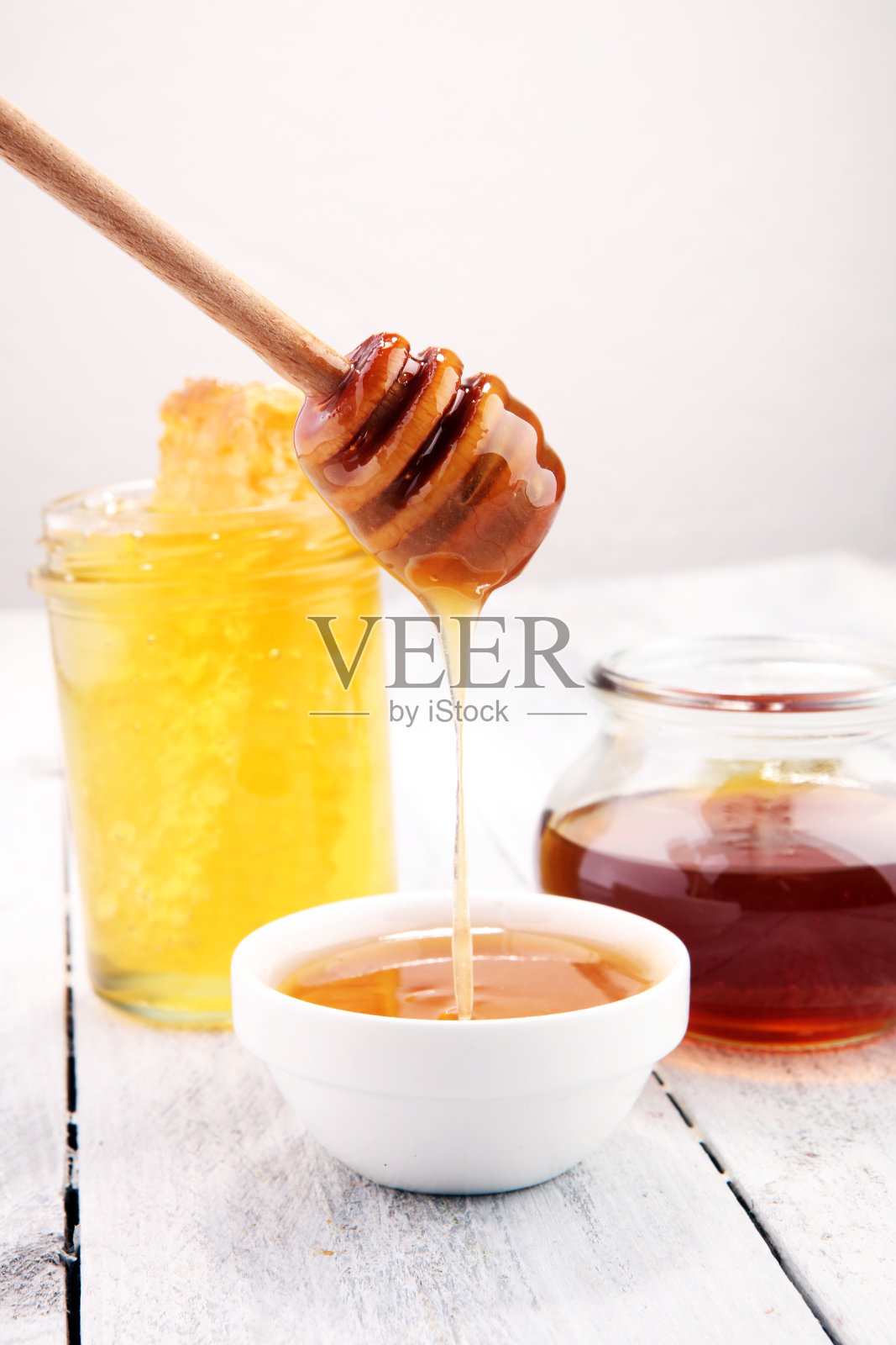把芳香的蜂蜜倒进罐子里，特写照片摄影图片