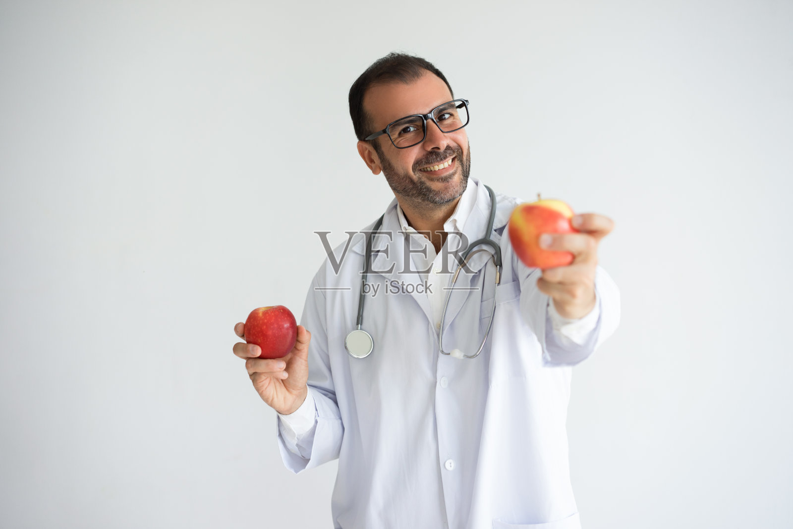 欢快的中年营养师戴着眼镜给苹果照片摄影图片