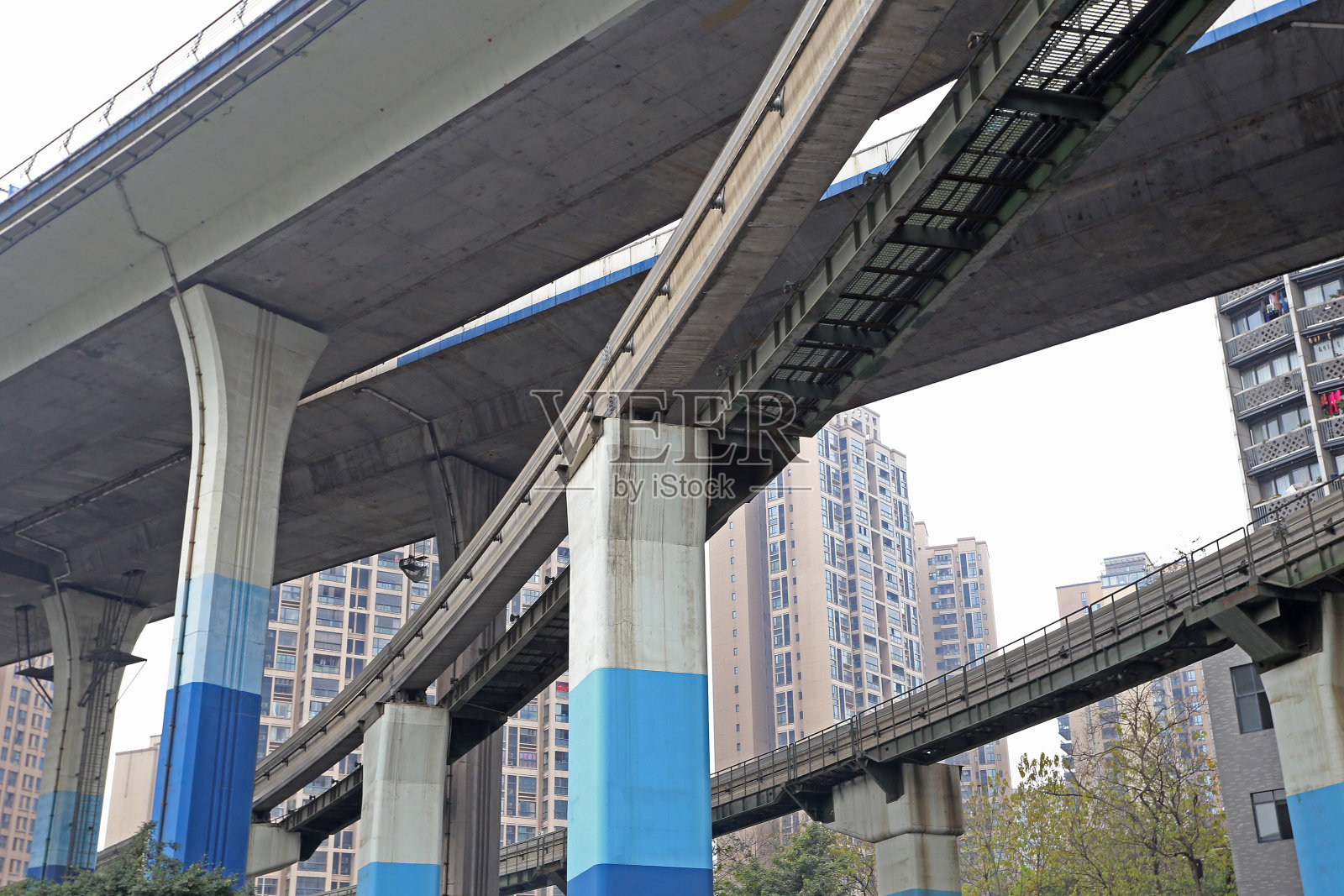 在中国重庆的高楼大厦中，空中火车轨道和立交桥照片摄影图片