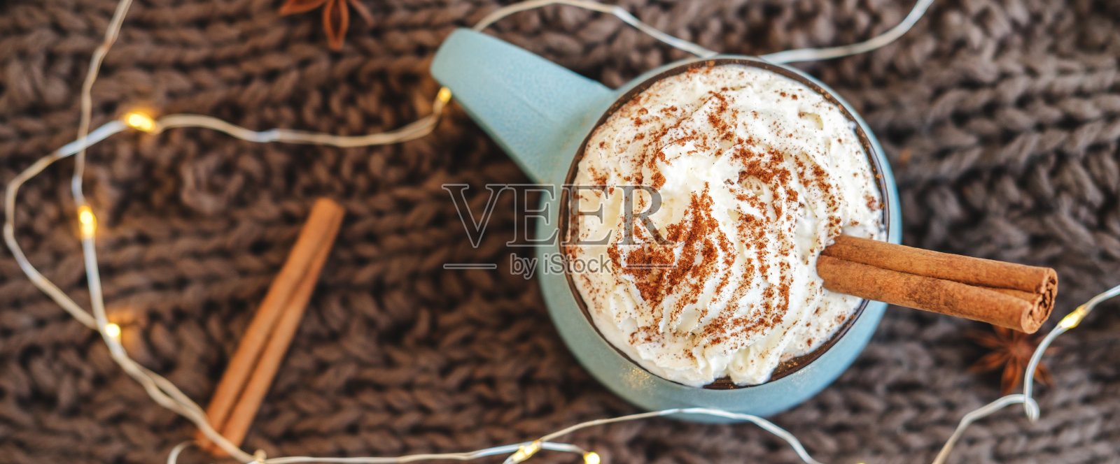 一杯咖啡，可可或热巧克力，加奶油和肉桂，围巾，花环，八角。南瓜拿铁是寒冷的秋天或冬天的舒适饮料。平的。前视图。照片摄影图片