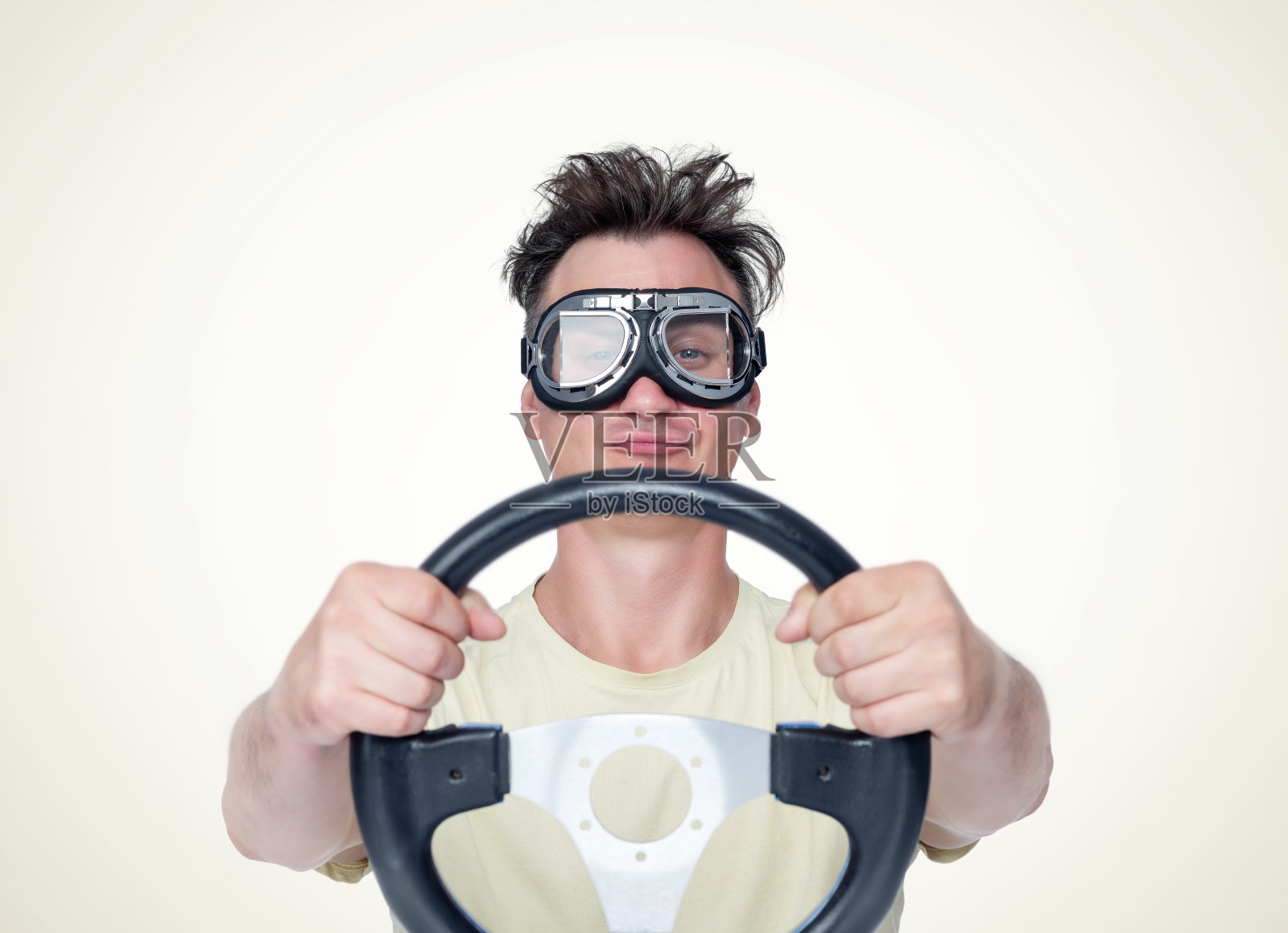男人在时尚的护目镜与方向盘在黄色的背景，汽车司机的概念照片摄影图片