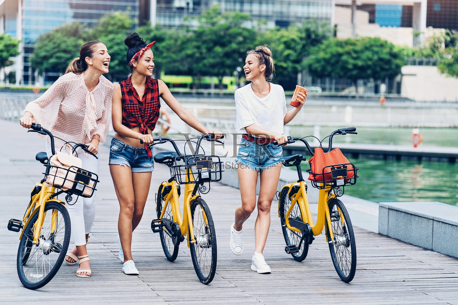 一群推着自行车走着的年轻女子照片摄影图片