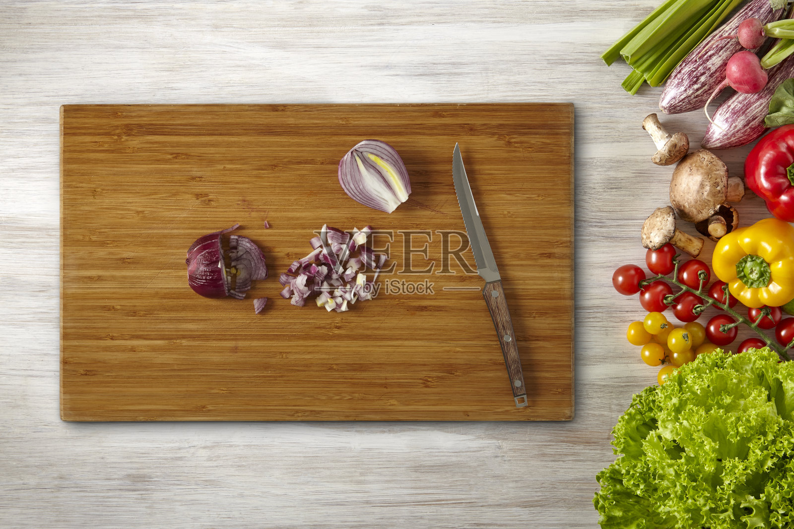 红洋葱用刀切在切菜板上，蔬菜架照片摄影图片