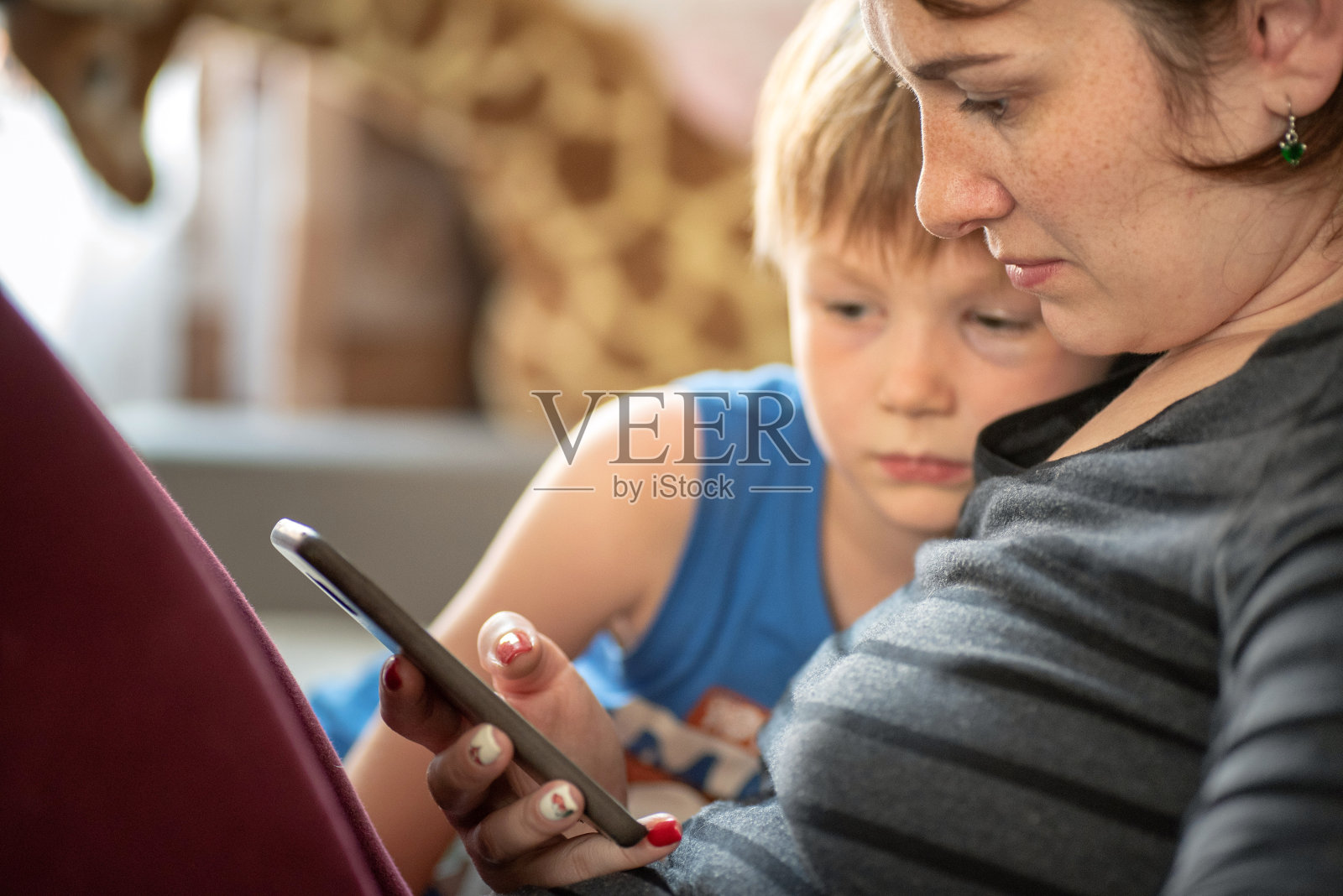 母亲和儿子在家里使用智能手机平板电脑照片摄影图片