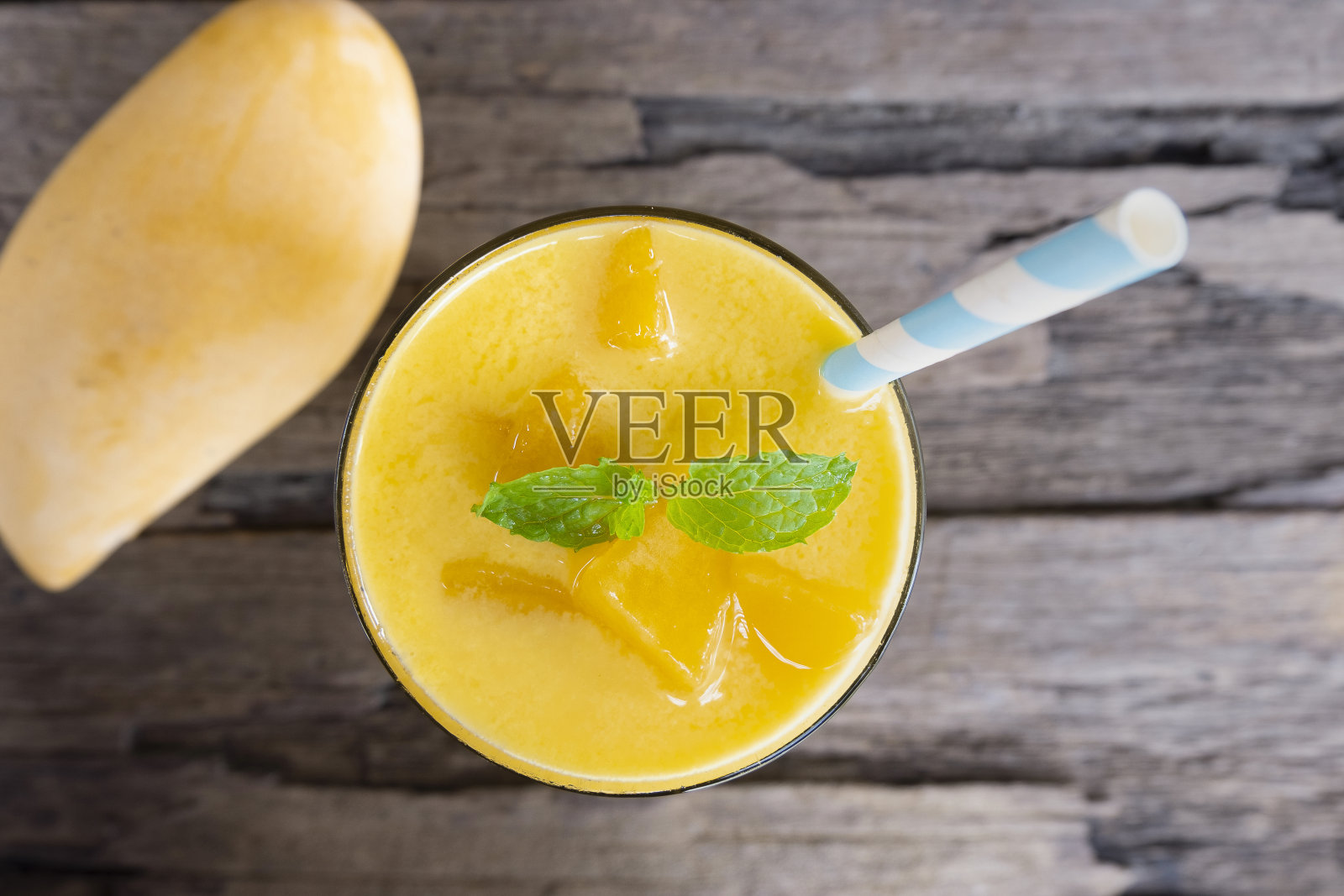 芒果冰沙五颜六色的橙汁饮料健康的味道美味的在玻璃饮料集早上在木制的背景从俯视图。照片摄影图片
