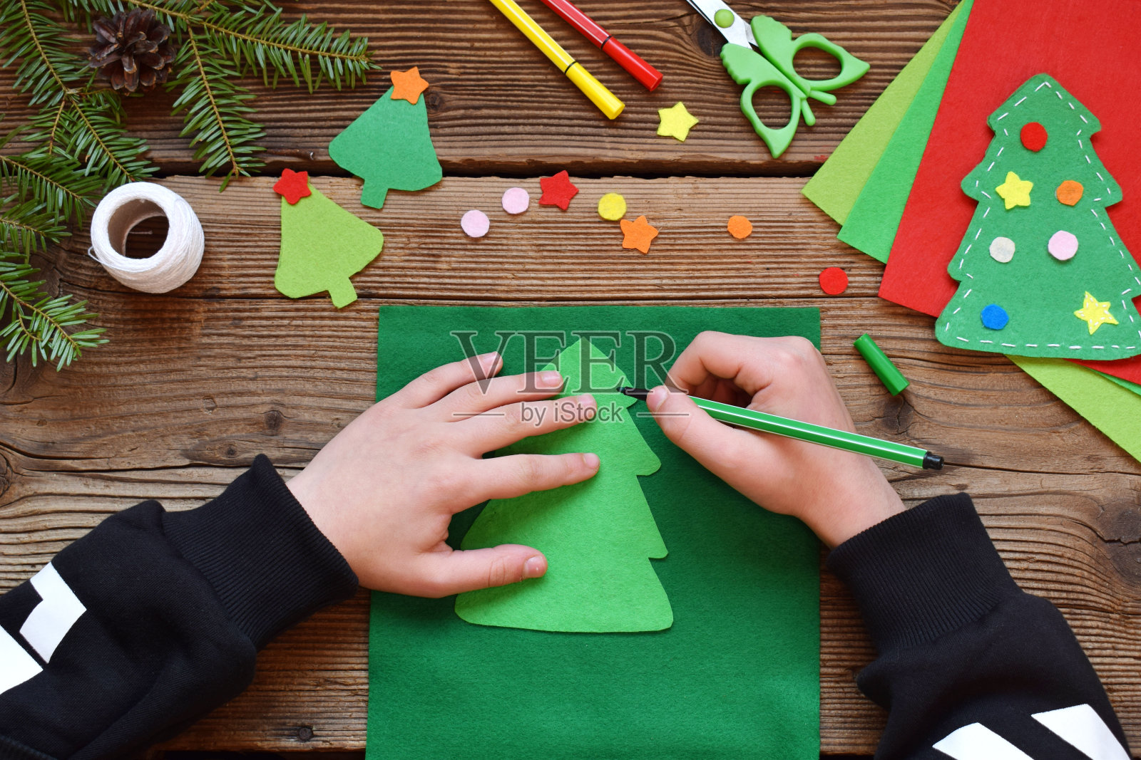 用你自己的手用毛毡手工制作圣诞树。孩子的DIY的概念。制作圣诞玩具、装饰品或贺卡。步骤1。圆模板。照片摄影图片