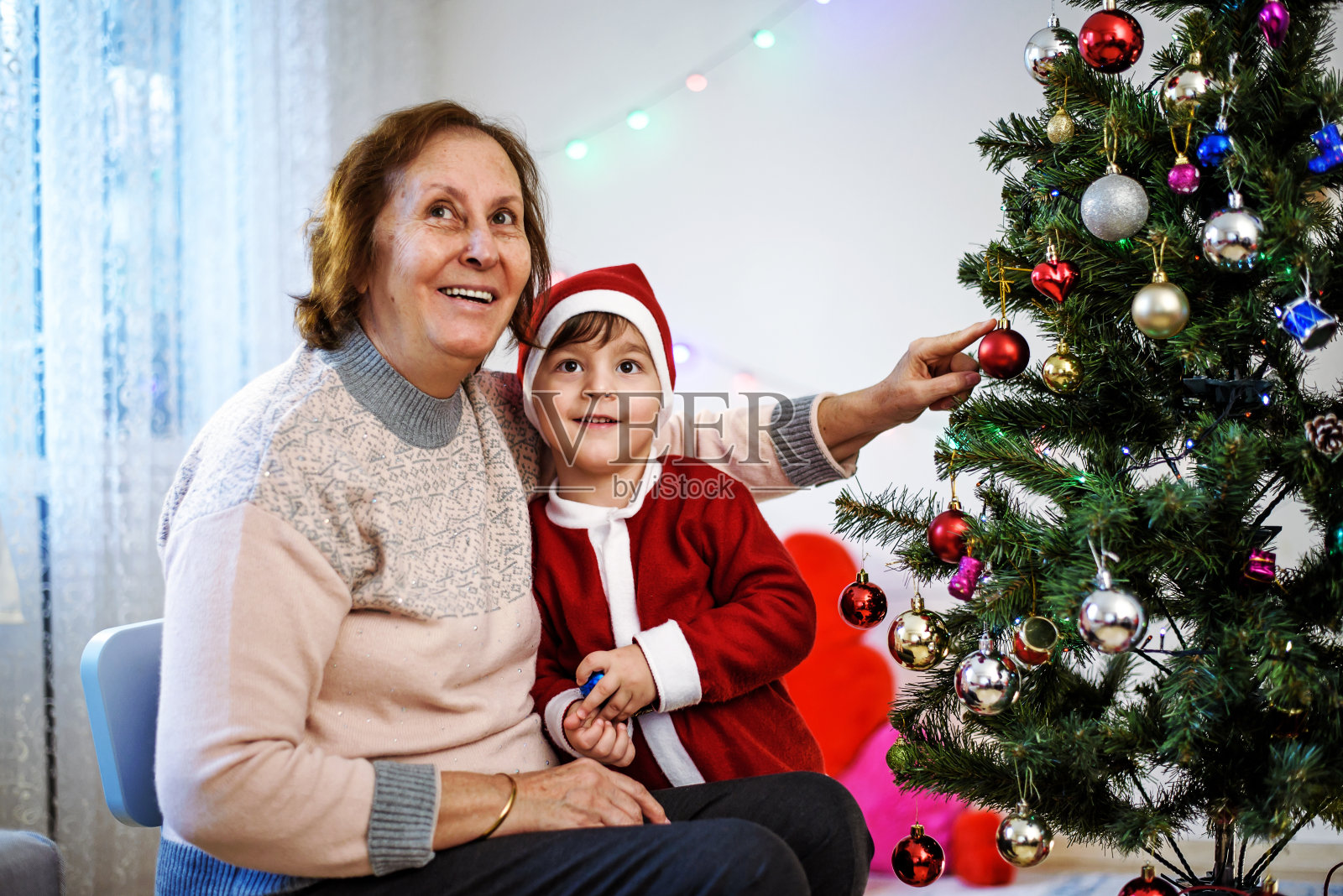 奶奶和孙子在装饰圣诞树照片摄影图片