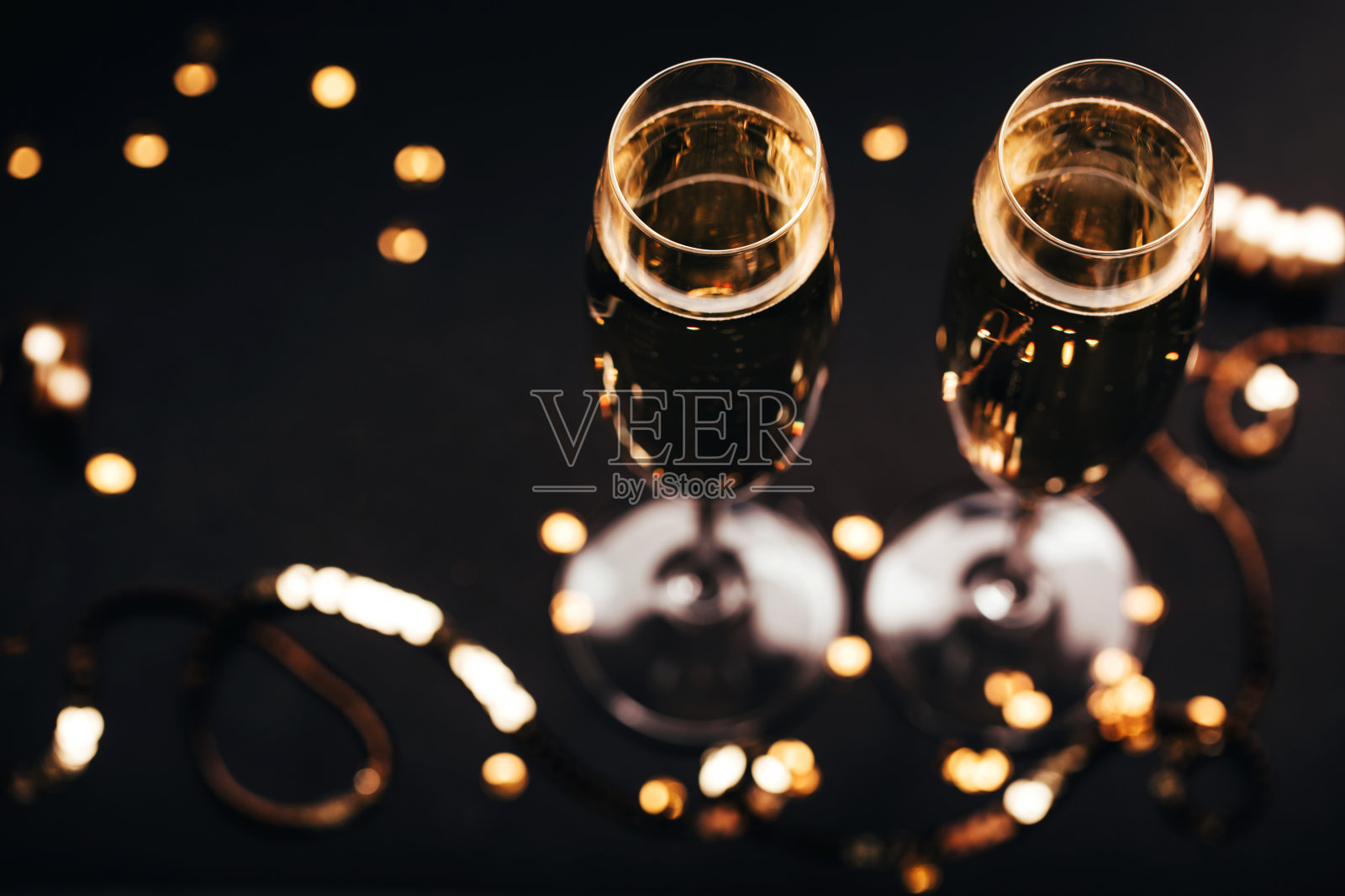 两杯香槟装饰在黑色优雅的背景上。照片摄影图片