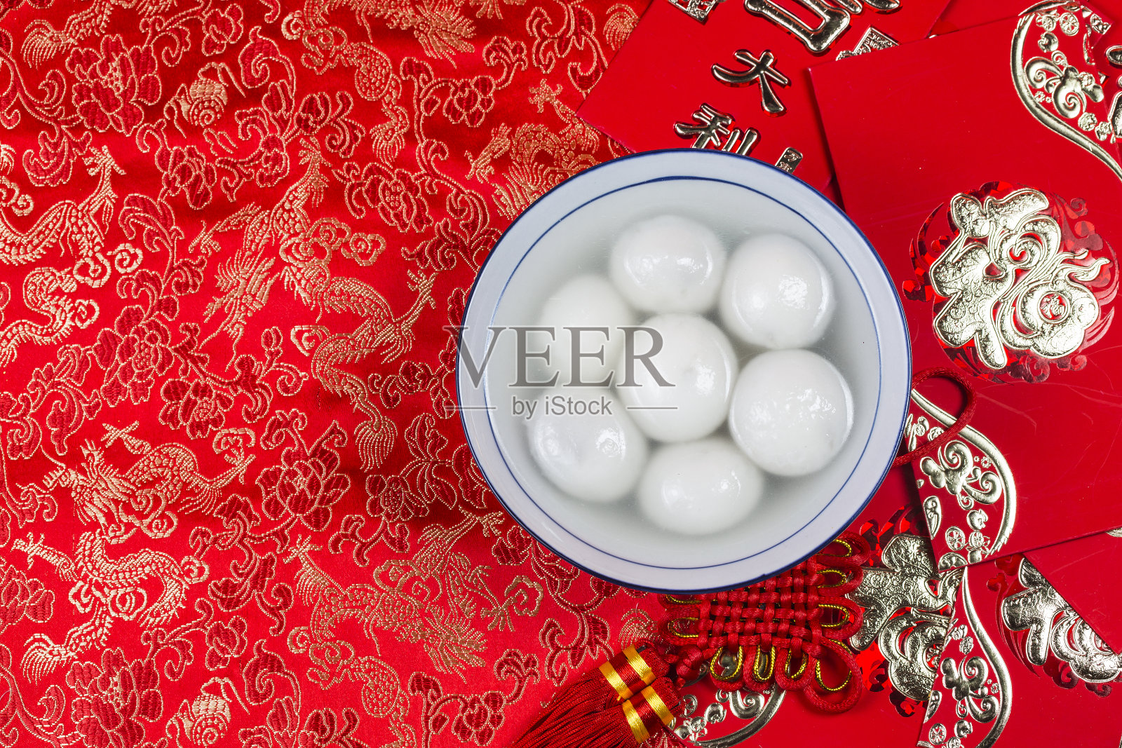 汤圆放在碗里放在桌上，红包和金元宝。汉字意味着好运和财富照片摄影图片
