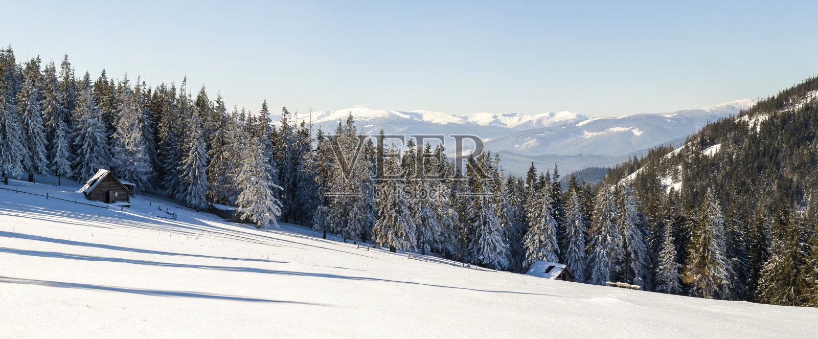 美丽的冬季景观在山上有雪小径在草原和小房子。新年快乐庆祝概念。照片摄影图片