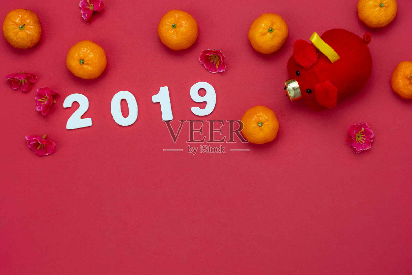 汉语的意思是富有或富有和幸福。桌面视图农历新年和中国新年的概念背景。平铺橙色在篮子和猪娃娃玩具儿童与2019文字细节在红纸上。照片摄影图片