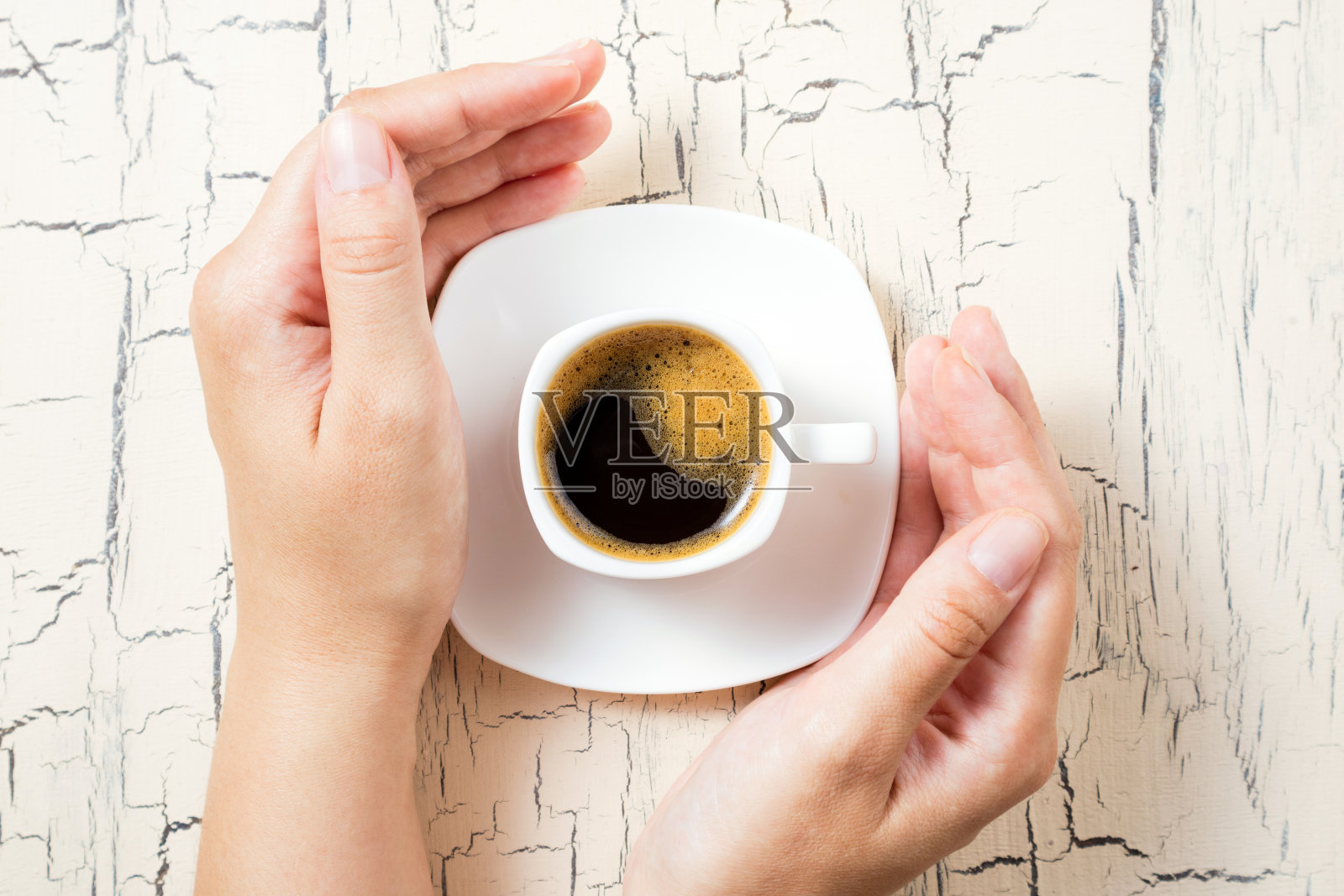 早餐喝一杯浓缩咖啡。女人的手和咖啡杯放在白色的餐桌上。俯视图照片摄影图片