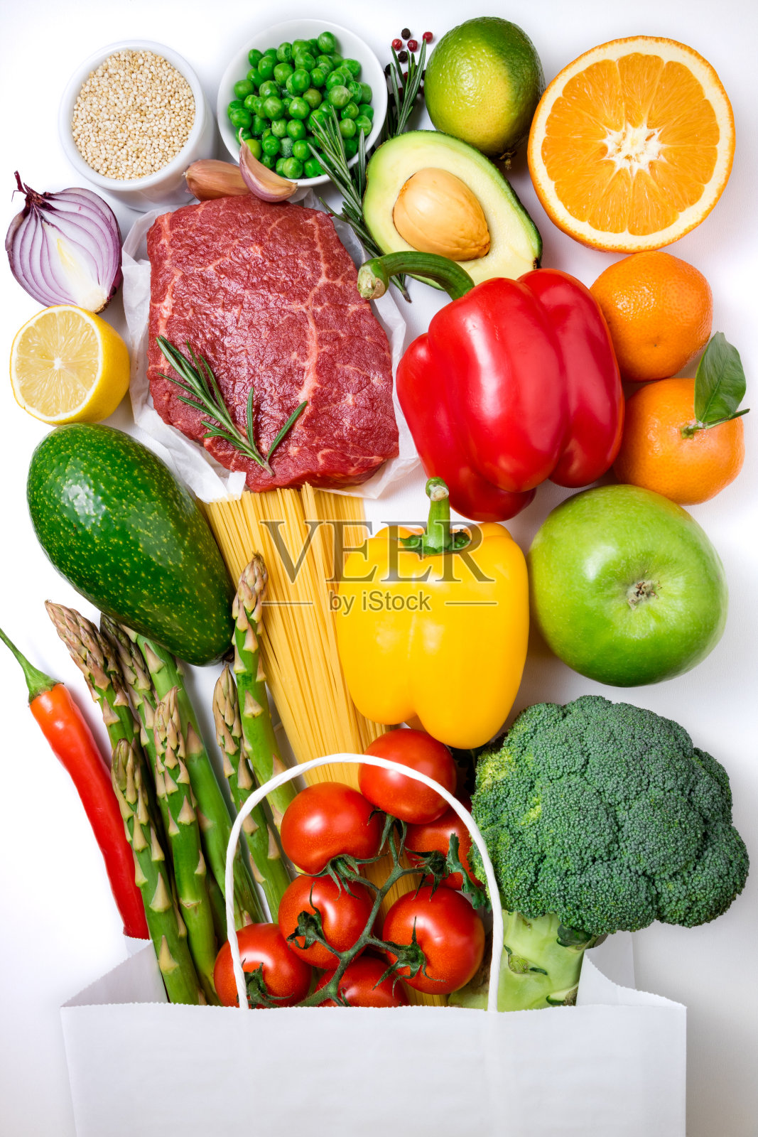 健康食品的背景。健康食品纸袋肉类，水果，蔬菜和意大利面在白色的背景。在超级市场购买食品照片摄影图片