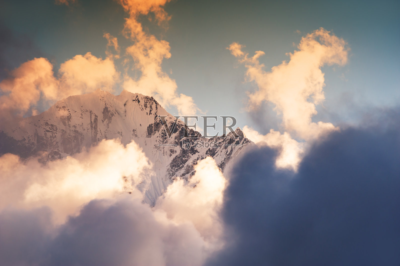 喜马拉雅山的顶峰在日落时有云。尼泊尔照片摄影图片