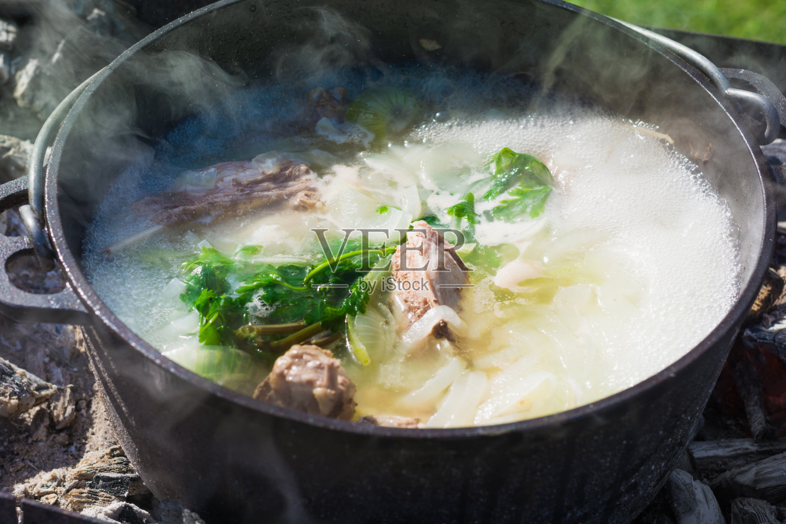 Shurpa汤在一个大铸铁锅户外。夏天徒步旅行的食物。照片摄影图片