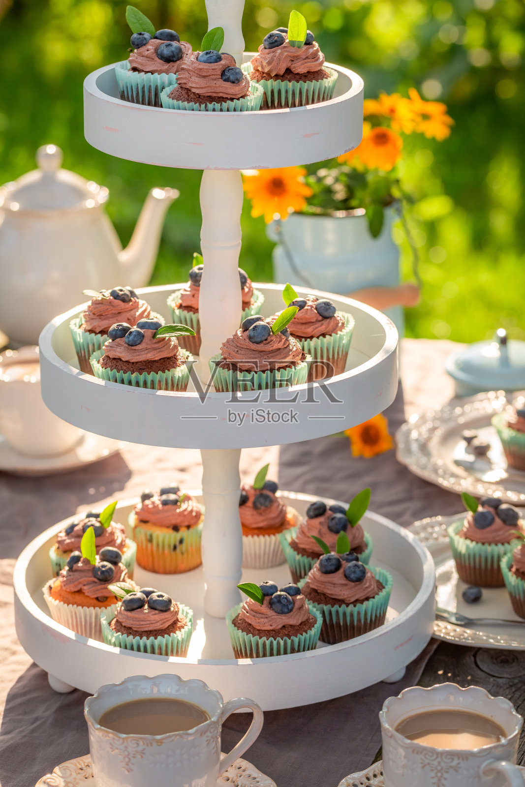 美味的棕色纸杯蛋糕和咖啡在花园照片摄影图片