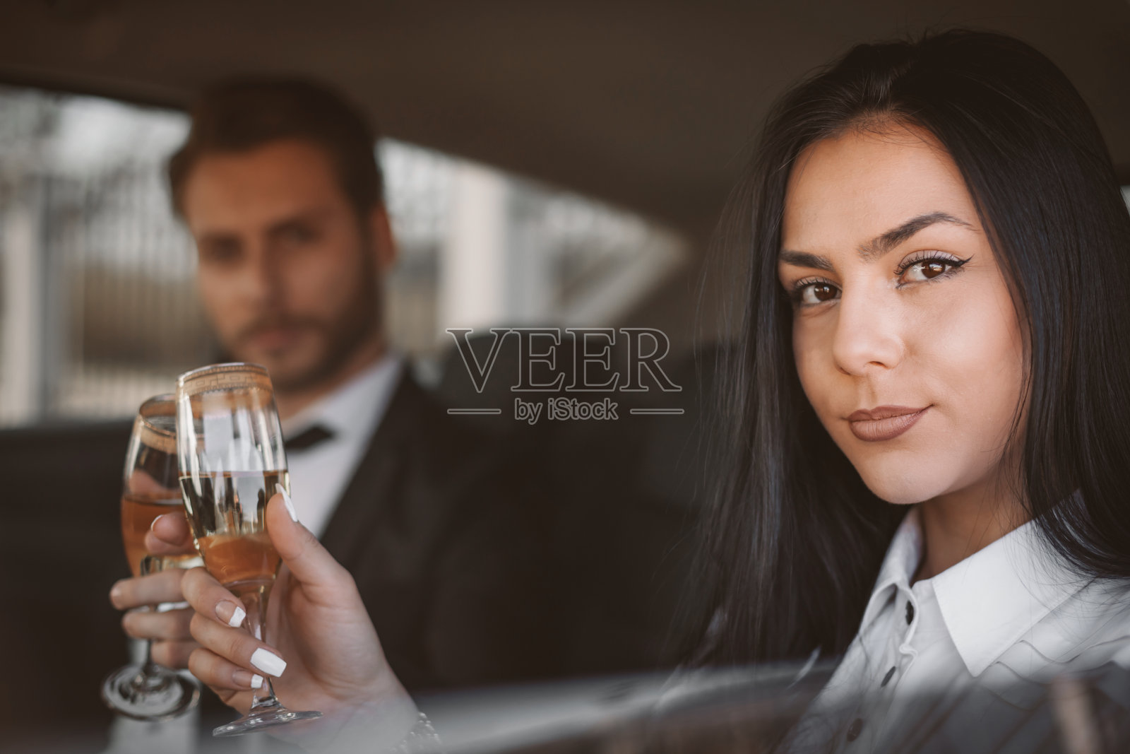商务人士在长途商务旅行后在车里喝香槟照片摄影图片