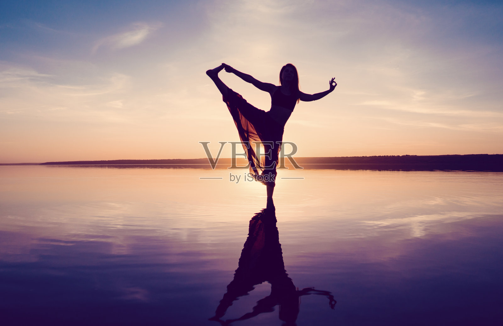 剪影瑜伽女人在海滩上日落。照片摄影图片