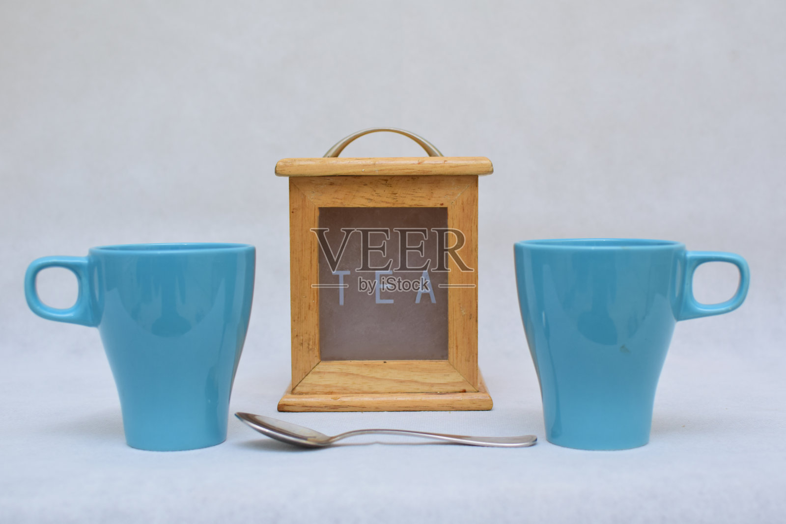 一套彩色陶瓷热饮杯旁边的木制茶盒孤立在白色的背景照片摄影图片