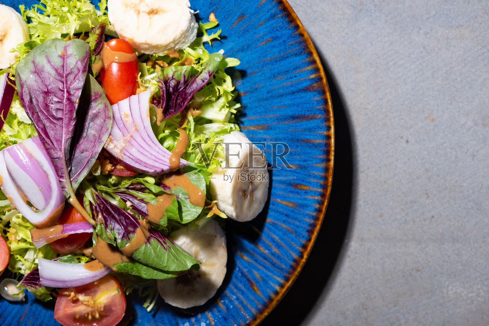 蓝色盘子里的蔬菜和水果沙拉照片摄影图片