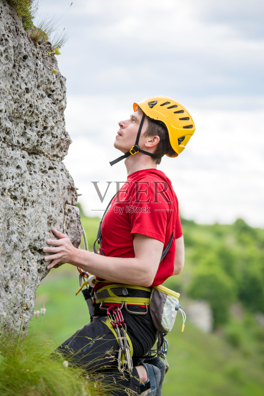 照片的运动员在黄色头盔爬过岩石的背景绿树照片摄影图片